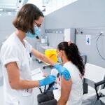 Una enfermera vacuna a una mujer en el Hospital público de emergencias Enfermera Isabel Zendal.