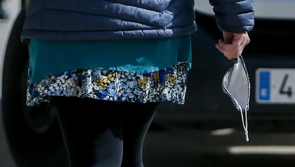 Una mujer camina con la mascarilla en la mano, a 10 de febrero de 2022, en Madrid (España). A partir de hoy las mascarillas dejan de ser obligatorias en exteriores. Además, se elimina la mascarilla en los recreos de los colegios. La única excepción es en eventos multitudinarios cuando las personas estén de pie y si están sentadas no guarden la distancia de 1,5 metros. 10 FEBRERO 2022;SALUD;MASCARILLAS;EXTERIORES;COVID;SALUD Ricardo Rubio / Europa Press 11/01/2022