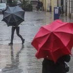 Imagen de archivo de dos personas sostenido paraguas a causa de la lluvia