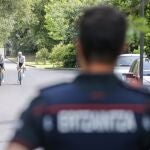Un ertzaina observa el entrenamiento de dos corredores del equipo Bahrain en Mungia (BIZKAIA).