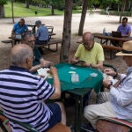 Unos jubilados juegan a las cartas en el madrileño parque del Retiro