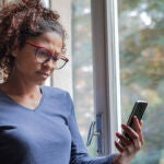 Una mujer mira el móvil preocupada
