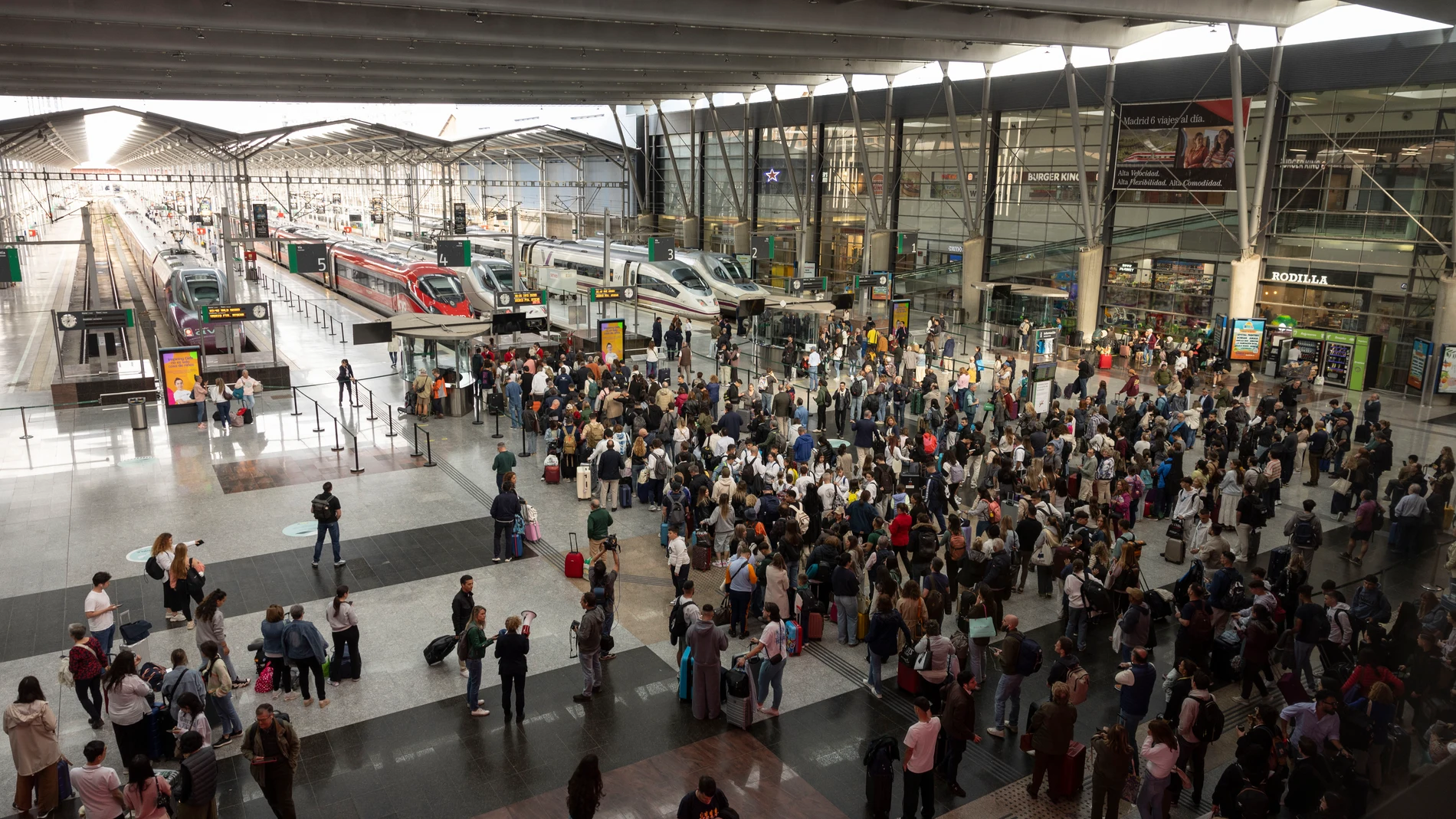 MÁLAGA, 05/05/2025.- Cientos de viajeros aguardan en los accesos a los andenes de la Estación María Zambrano de Málaga la reanudación del servicio de alta velocidad este lunes tras el robo de cable en cuatro puntos de la provincia de Toledo que ha dejado miles de pasajeros afectados. EFE/Jorge Zapata
