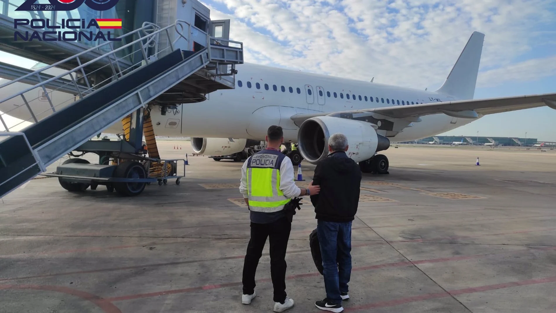 Imagen de un agente con un detenido en el aeropuerto