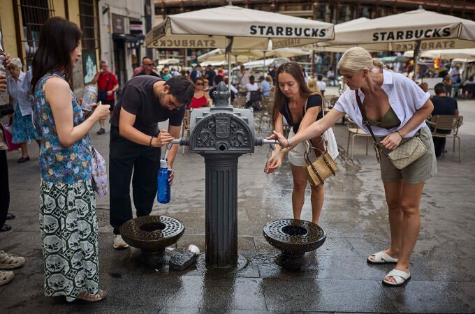 Turistas en plena ola en la ciudad de Madrid intentan refrescarse en las fuentes de agua 