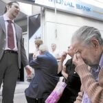 Varios pensionistas esperan a las puertas de los bancos