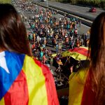 Dos estudiantes observan una de las columnas de las marchas por la libertad