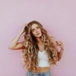 En la imagen, una mujer de pelo largo y rizado.