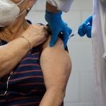 Un enfermero vacuna a una mujer en Madrid