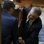 El ministro del Interior, Fernando Grande-Marlaska, se acerca al escaño del presidente del Gobierno, Pedro Sánchez