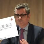 En primer plano, la respuesta de Félix Bolaños a la citación del juez Juan Carlos Peinado a la que ha accedido LA RAZÓN, y al fondo, el ministro de Justicia, en una fotografía reciente